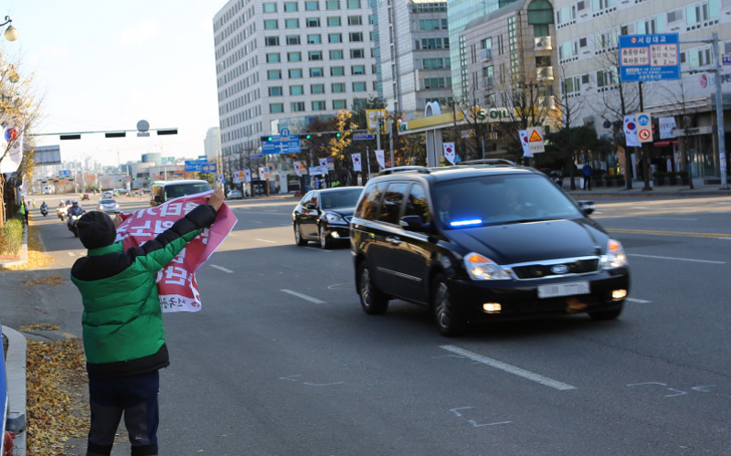 ▲ 공무원노조 조합원이 대통령이 타고 있는 차량 앞에서 펼침막을 들고 서 있다. 사진=김상호 기자