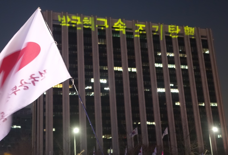 ▲ 대회 중 서울 정부청사 건물 상단에 '박근혜 구속 조기탄핵' 문구를 레이저로 띄웠다.