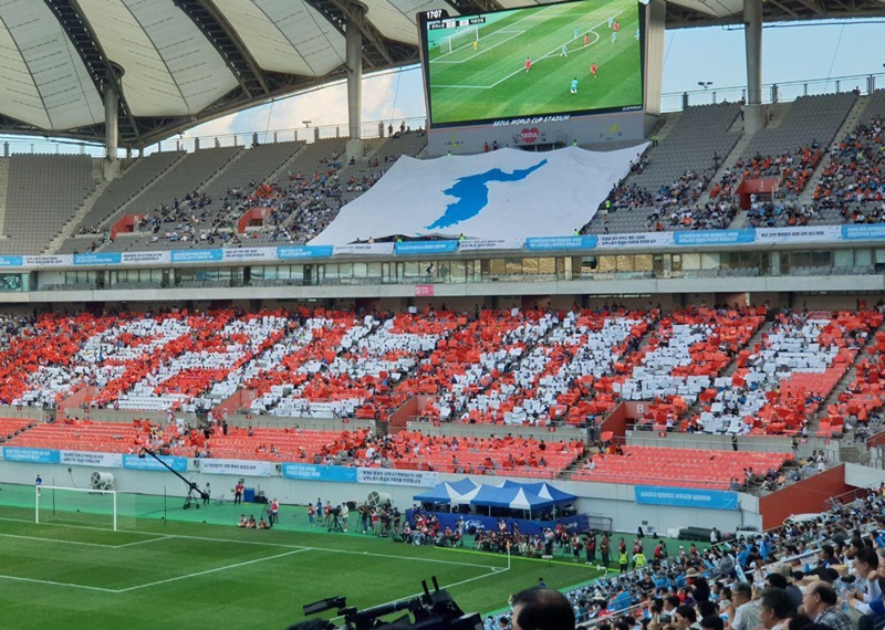 ▲ 11일 서울 상암 월드컵경기장에서 펼쳐진 남북노동자통일축구대회에서 관중들이 빨간색 바탕에 흰색 글씨로 '우리는 하나'라는 카드섹션을 선보였다. 사진 = 공무원노조
