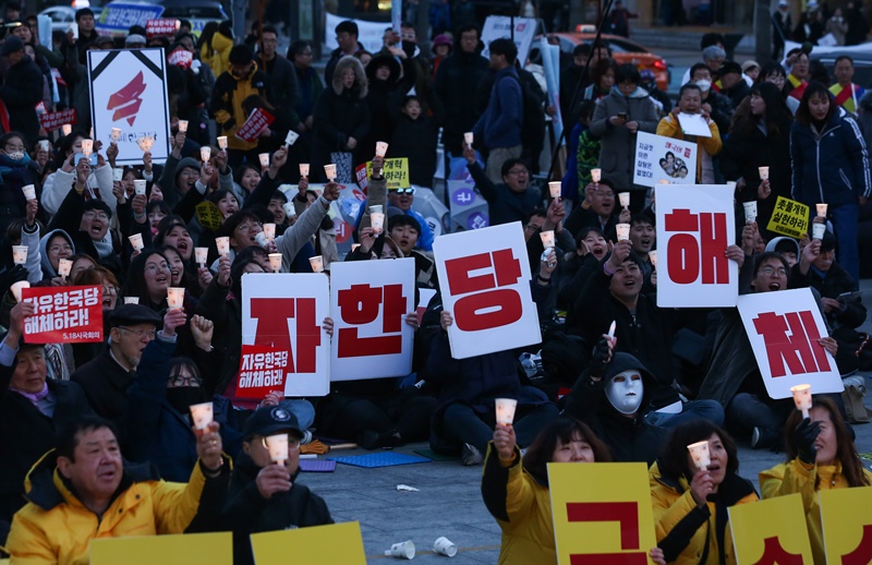 ▲ 자유한국당 해체 범국민촛불대회에서 참가자들이 '자한당 해체'라고 적힌 피켓과 촛불을 들고 있다.