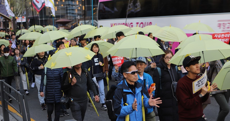 ▲ 시국대회 참가자들이 노란 우산을 들고 행진하며 세월호 희생자들을 추모했다.
