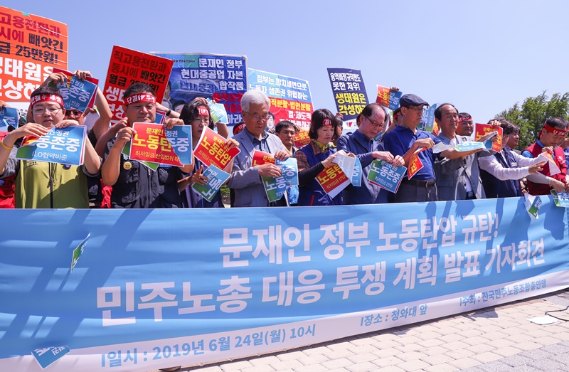 ▲ 문재인정부의 노동탄압 규탄 기자회견에서 참석자들이 상징의식을 하며 피켓을 손으로 찢고 있다.