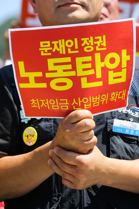▲ 민주노총 조합원이 '노동탄압 규탄' 피켓을 들고 있다.