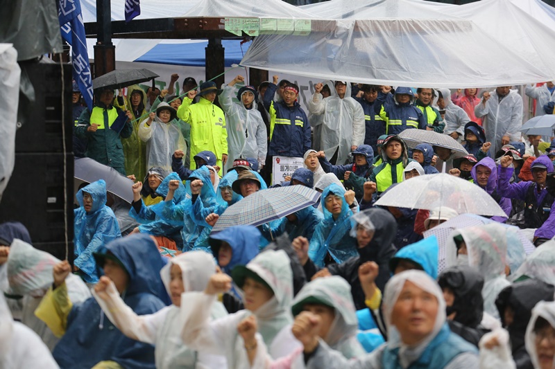 ▲ 결의대회 참가자들이 폭우속에서 구호를 외치고 있다.