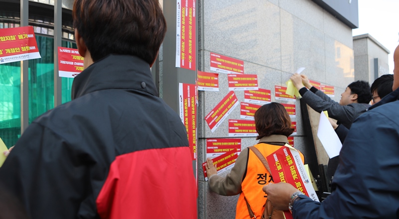 ▲ 행안부 입구 외벽에 항의 스티커를 붙이는 공무원 노동자들