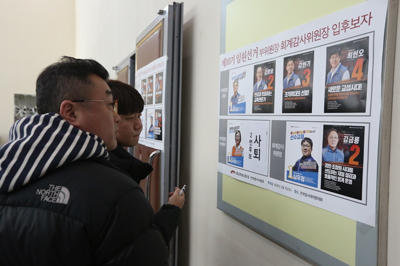 ▲ 대의원들이 후보자들의 포스터를 보고 있다.