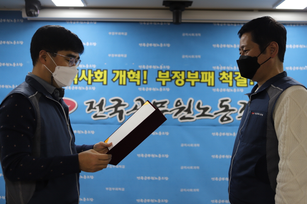 ▲ 최종덕 선거관리위원장이 김태성 11기 사무처장 당선자에게 당선증을 교부하고 있다.
