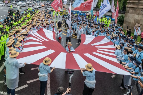 행진을 마친 통일선봉대가 일본대사관 앞에서 욱일기를 찢는 상징의식을 하고 있다. 