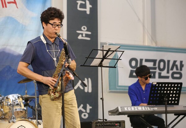 김용기 강남구지부장이 아들과 함께 색소폰 연주를 선보이고 있다.