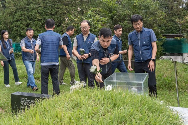 故 차봉천 초대 위원장 15주기 추모식 참가자들이 김원근 전 경기본부장의 묘역에 헌화하고 있다.