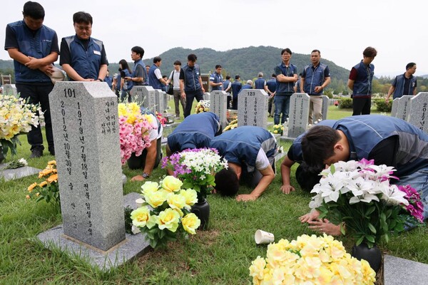 수련회 참가자들이 대전현충원의 소방공무원 묘역을 참배하고 있다.