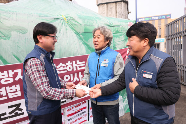 최상규 충북본부장이 김춘원 전북본부장에게 투쟁기금을 받고 있다.